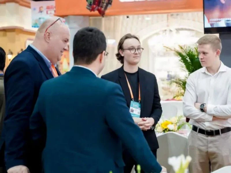 Kolegovia sa rozprávajú pri veľtržnom stánku