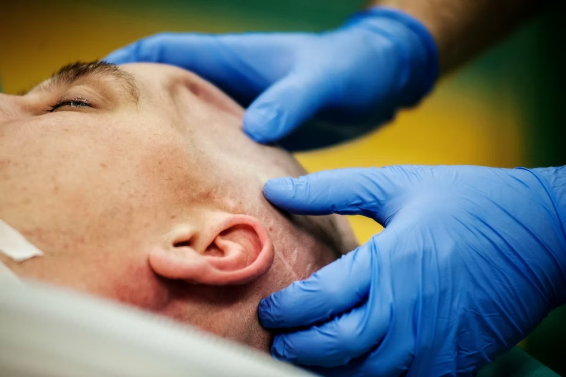 A surgeon examining a patient’s jaw