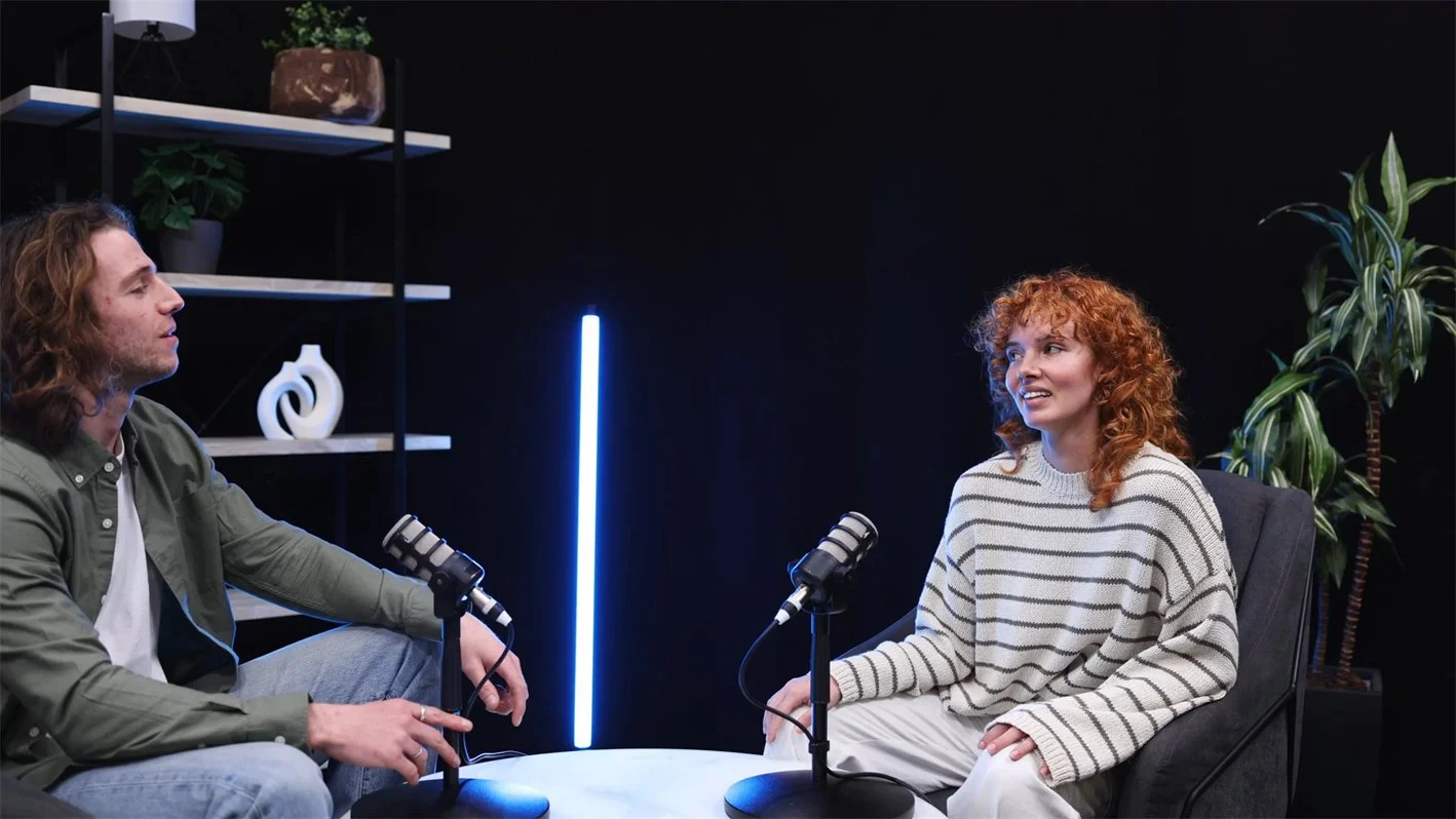 Two people talking in a podcast studio